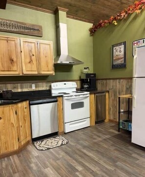 Una cocina con armarios de madera, una estufa y un refrigerador.