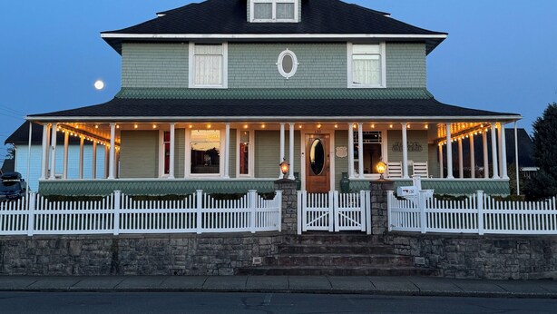 A two-story house with a porch, a mailbox, and a number 130 sign. - Hubble House Inn (Montesano)