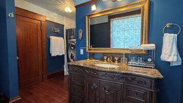 A bathroom with a dark wooden vanity, a large mirror, and a towel rack.