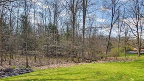 A grassy area with trees and a small body of water. - Cozy DuBois Home w/ Deck ~ 8 Mi to Treasure Lake! (DuBois)