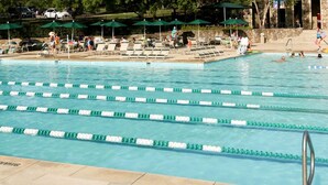 A swimming pool with multiple lanes, lounge chairs, and umbrellas. - Adorable Bungalow, Minutes from Downtown Durham (Durham)
