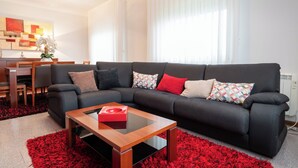 A modern living room with a sectional sofa, a wooden coffee table, and a red shag rug.