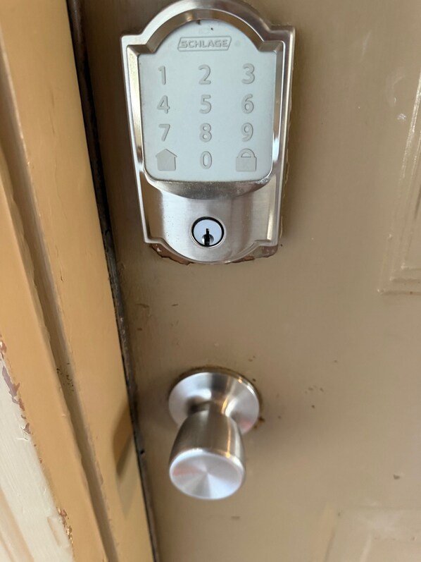 Una puerta con teclado numérico y mirilla debajo.