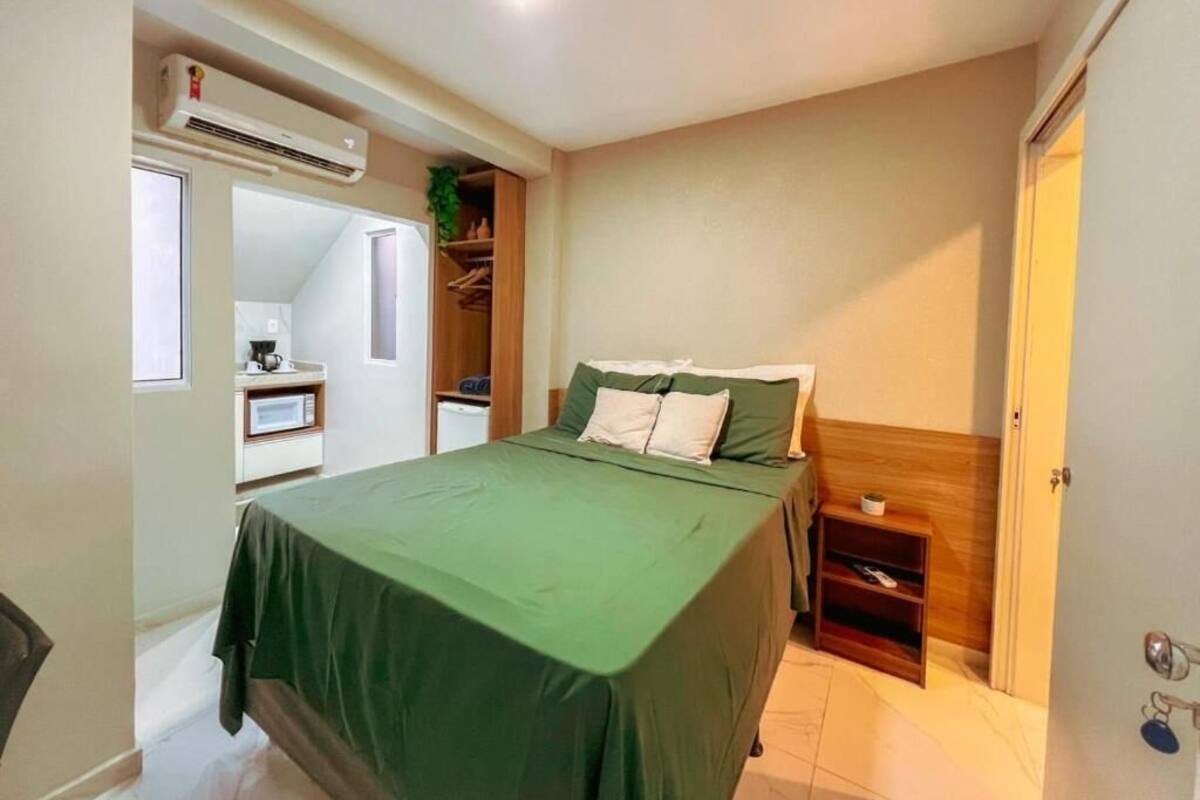 A bedroom with a bed, bedside table, and an air conditioning unit.