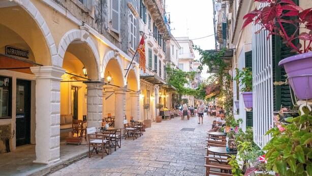 A cobblestone street with outdoor seating, arches, and potted plants. - Guilford Elegance | Corfu Old  town Apartment | fast WiFi (Corfu)