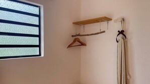 A room with a window, wooden shelves, and a hanging towel. - Sac Ek Hotel (Valladolid)