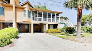 A two-story house with a balcony, a staircase, and a palm tree in the yard. - Mercy Me by Tybee Vacation Rentals (Tybee Island)