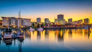 A marina with boats docked, a city skyline in the background, and a bridge crossing the water. - Private Getaway Near Beaches & Downtown Tacoma! (Tacoma)