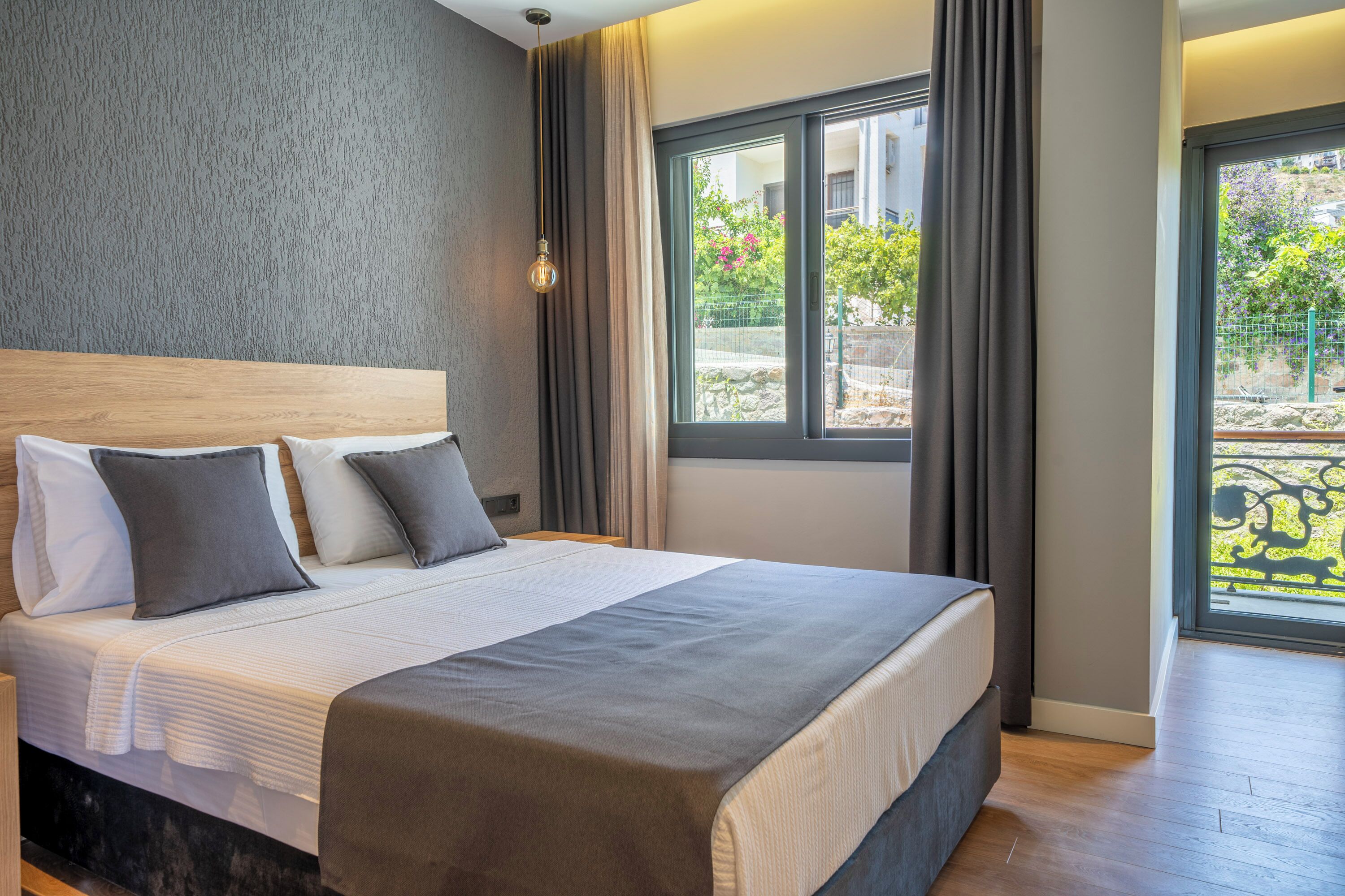 Una camera d'hotel moderna con un letto grande, vista sull'esterno e una parete strutturata.