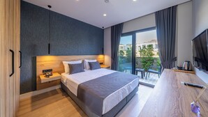 Une chambre moderne avec un grand lit, un bureau et une vue sur l’extérieur.