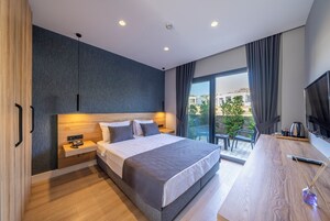 Un dormitorio moderno con una cama grande, un escritorio y vistas al exterior.