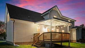 A two-story house with a covered porch and a wooden deck. - Stunning 5 Bed 2.5 Bath in the Heart of Clarksville (Clarksville)