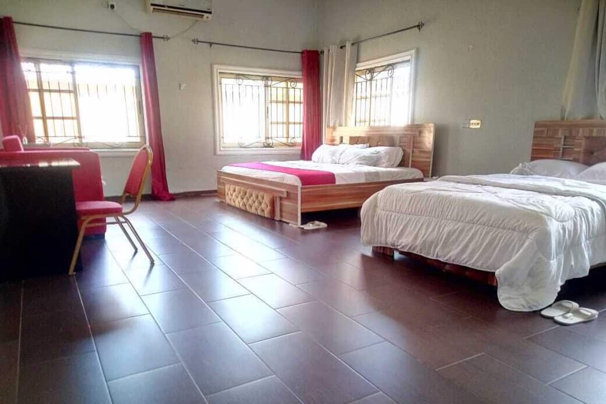 Een kamer met twee bedden, een bureau en een stoel.