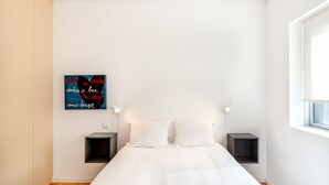 A minimalist bedroom with a large bed, two bedside tables, and a wall-mounted artwork. - VIVA  Nanda's  Place (Porto)
