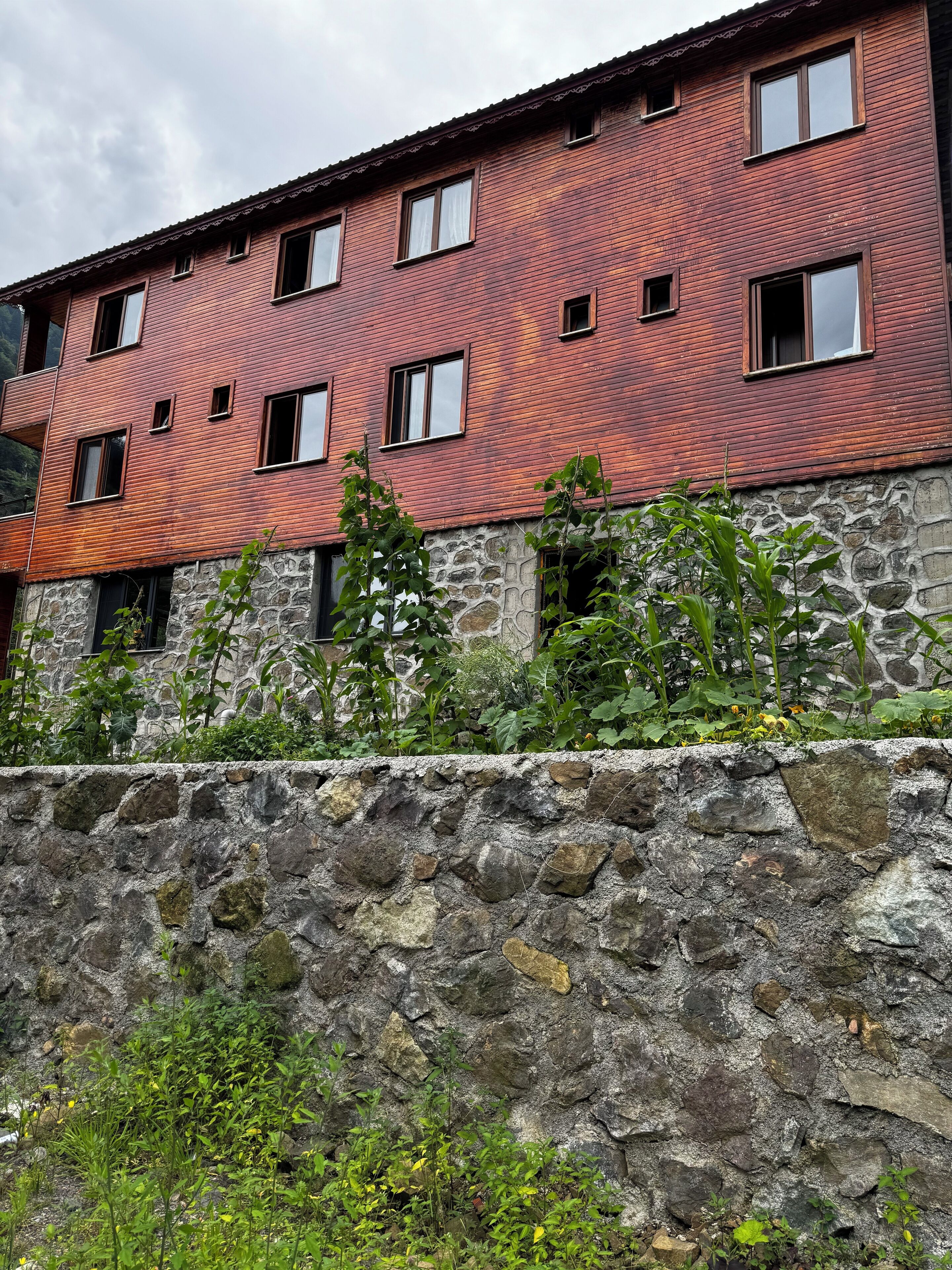 Un edificio de varios pisos con fachada de madera roja y base de piedra.