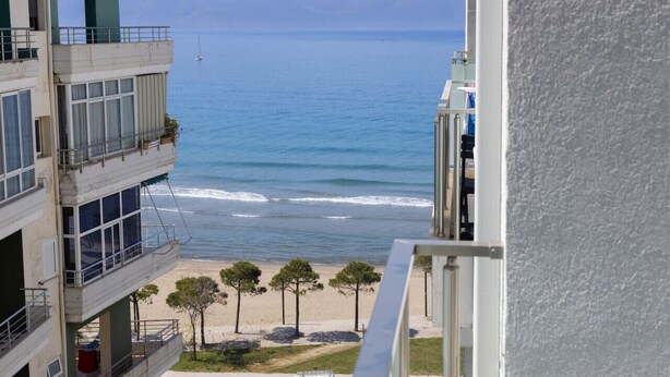 A view of a beach with a building in the foreground. - Central Seaview Apartment by PikHost (Vlorë)