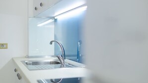 A modern kitchen with a stainless steel sink, a faucet, and a backsplash. - Central Seaview Apartment by PikHost (Vlorë)
