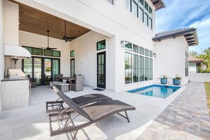 A modern house with a swimming pool, outdoor seating, and a covered patio area. - Casa Mar (Destin)