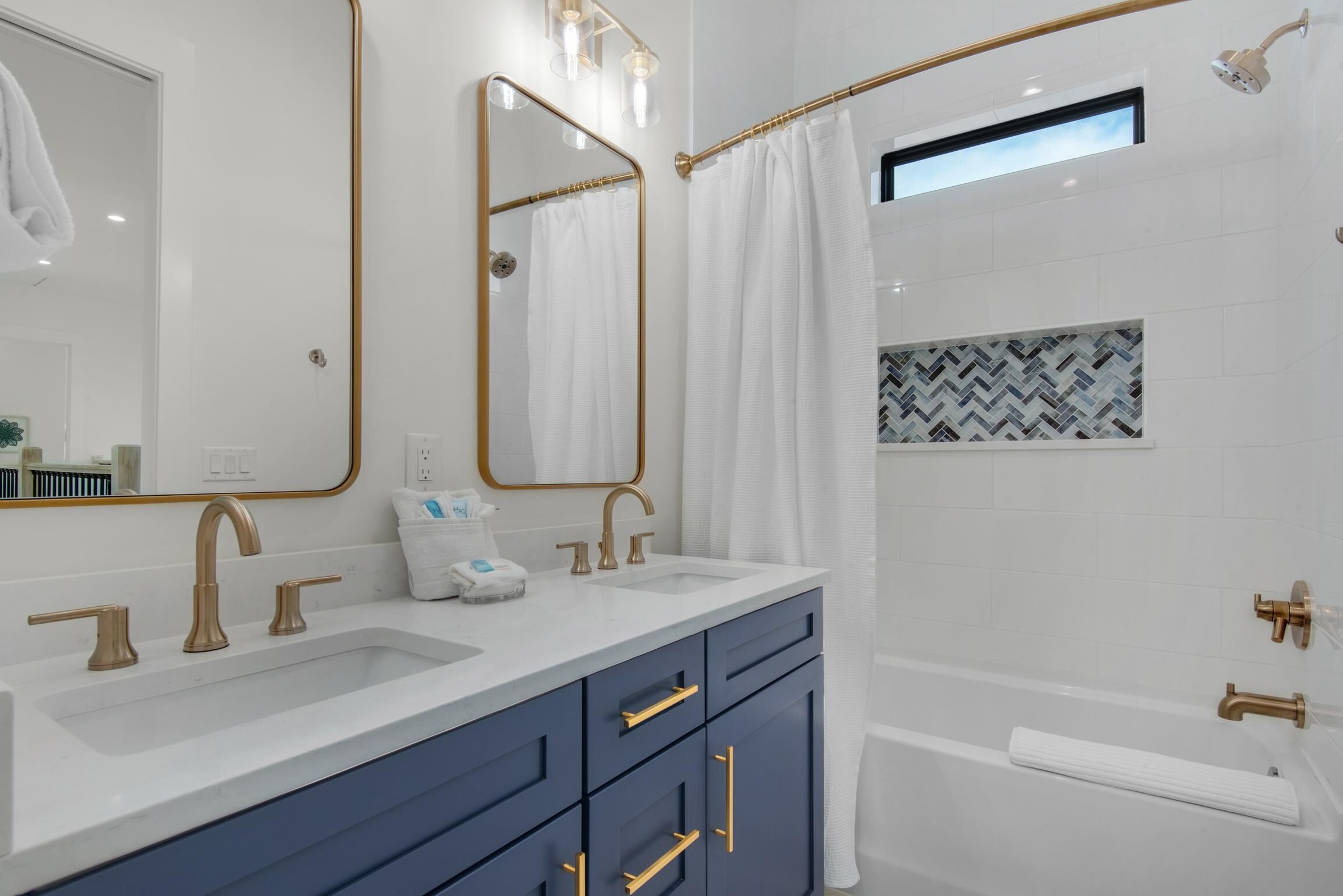 Une salle de bain moderne avec un meuble-lavabo à deux vasques, un grand miroir et un espace douche.