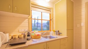 Eine Küche mit Fenster, Spüle und einer Arbeitsplatte mit diversen Gegenständen.