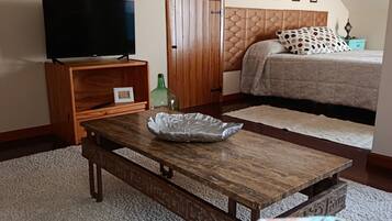 Ein Schlafzimmer mit einem Bett, einem Fernseher, einem Holztisch und einem Kleiderschrank.
