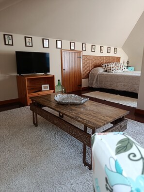 Una camera da letto con un letto, una televisione, un tavolino in legno e un armadio.