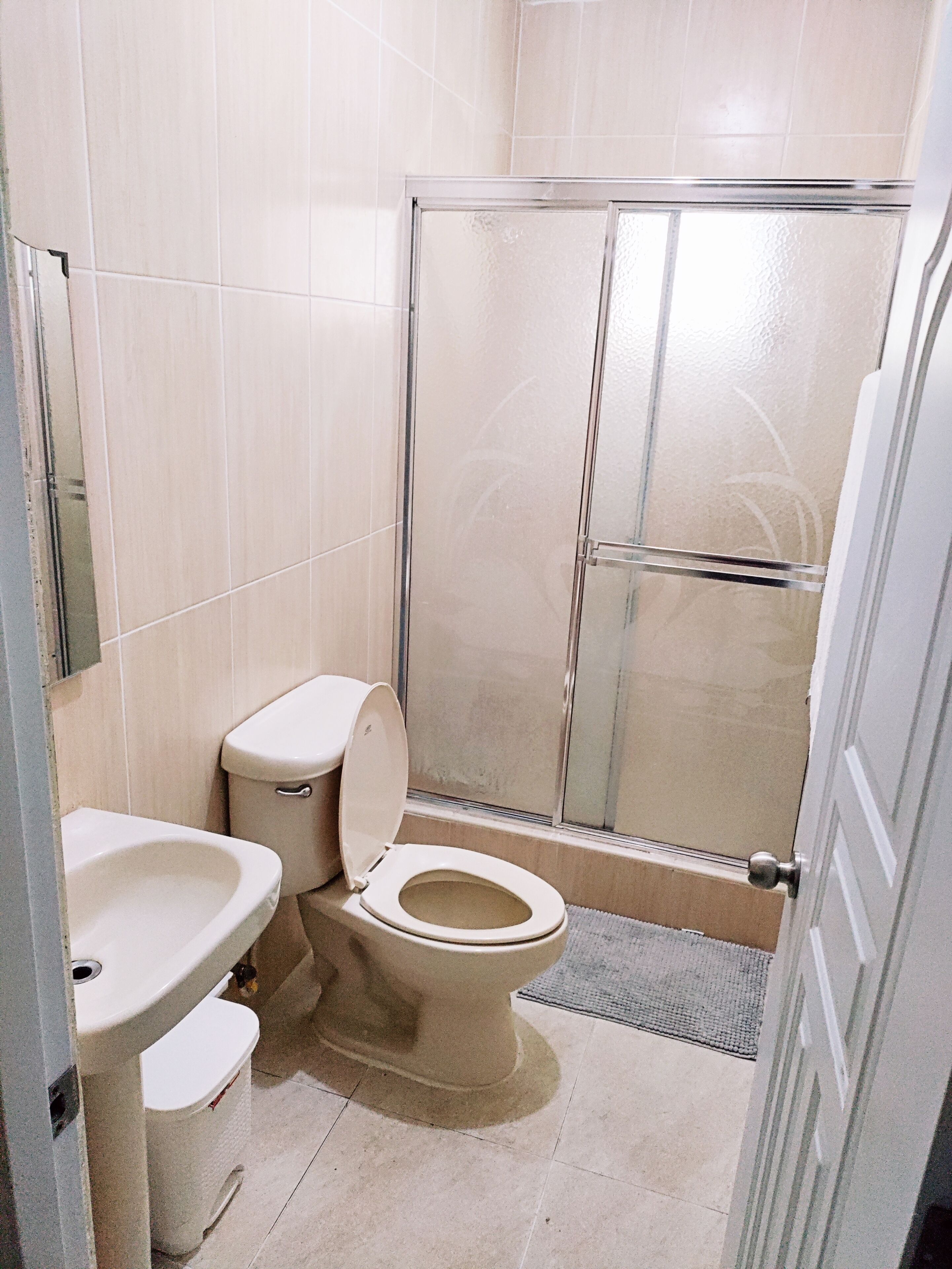 A bathroom with a toilet, sink, and shower.