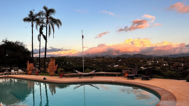 A swimming pool with a view of palm trees and a sunset. - Fallbrook’s guest-pool house : An old Hollywood stars escape (Fallbrook)