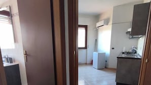 A spacious kitchen with a tiled floor, a built-in stove, and a window providing natural light.