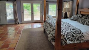 Un dormitorio con cama con dosel, un ventanal y vistas al exterior.