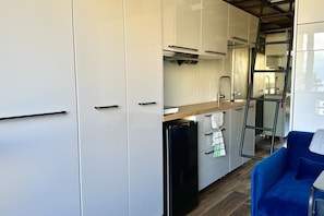 A modern kitchen with white cabinets, a black refrigerator, and a wooden countertop. - SE078- Senigallia, new sea front studio at the ''Pyramids'' (Senigallia)