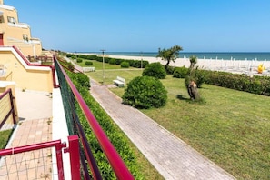 A pathway leading to a beach, with a fence on one side and a building on the other. - SE078- Senigallia, new sea front studio at the ''Pyramids'' (Senigallia)