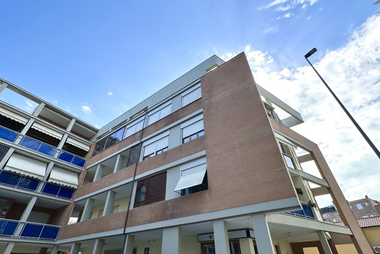 Un edificio a più piani con balconi, ampie finestre e cielo sereno.