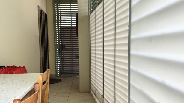 A room with a dining table, chairs, a window with blinds, and a door with a metal gate. - SE076 - Senigallia, three-room apartment convenient to services (Senigallia)
