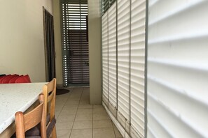 A room with a dining table, chairs, a window with blinds, and a door with a metal gate. - SE076 - Senigallia, three-room apartment convenient to services (Senigallia)