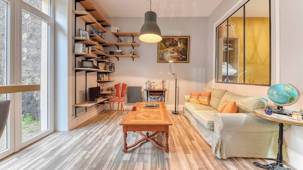 Una sala de estar acogedora con una mesa de centro de madera, un sofá, una estantería y un globo terráqueo en una mesita.