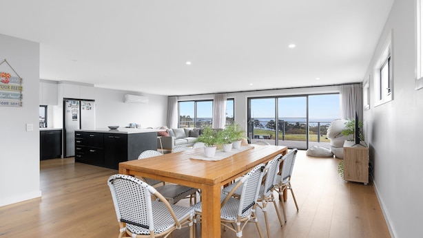 A modern kitchen with a dining area, large windows, and a view of the outdoors. - Casa La Pose San Remo gateway to Phillip Island (San Remo)