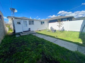 A single-story house with a front yard, a satellite dish, and a garage.