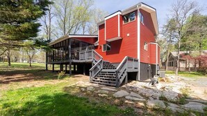 A red building with a balcony and a staircase leading to the entrance.