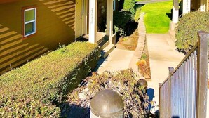 A residential area with yellow houses, a clear sky, and a hilly landscape in the background. - C03 Spacious 3BR Townhouse on the Golf Course (Quincy)