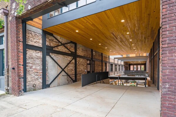 A spacious interior with exposed brick walls, a wooden ceiling, and a mezzanine level.