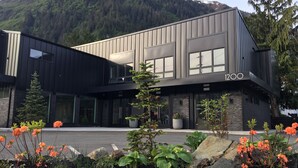 A modern building with a flat roof, large windows, and a stone facade. - Chalet Suite in Downtown Juneau (Juneau)