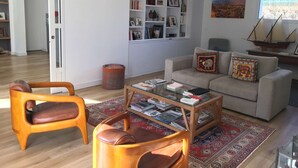 A living room with a sofa, two armchairs, a coffee table, and a bookshelf. - Maison Proche Plage Pour 8 Avec Jardin et Internet (ARZON)