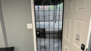 A door with a metal security gate, a keypad lock, and a small sign on the wall. - Sheridan Lodge is a vibrant and safe neighborhood in Washington, DC. (Washington)
