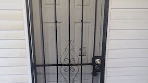 A black metal gate with a mesh design, a doorknob, and a small step leading up to it. - Sheridan Lodge is a vibrant and safe neighborhood in Washington, DC. (Washington)