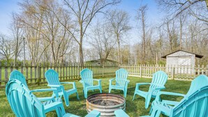 A backyard with a fire pit surrounded by turquoise Adirondack chairs. - Benton Harbor Home w/ Fire Pit - 2 Mi to Beach! (Benton Harbor)