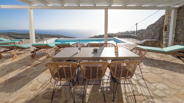 A covered outdoor area with a pool, lounge chairs, and a table with chairs. - Villa Prive 77 Mykonos (Mykonos)