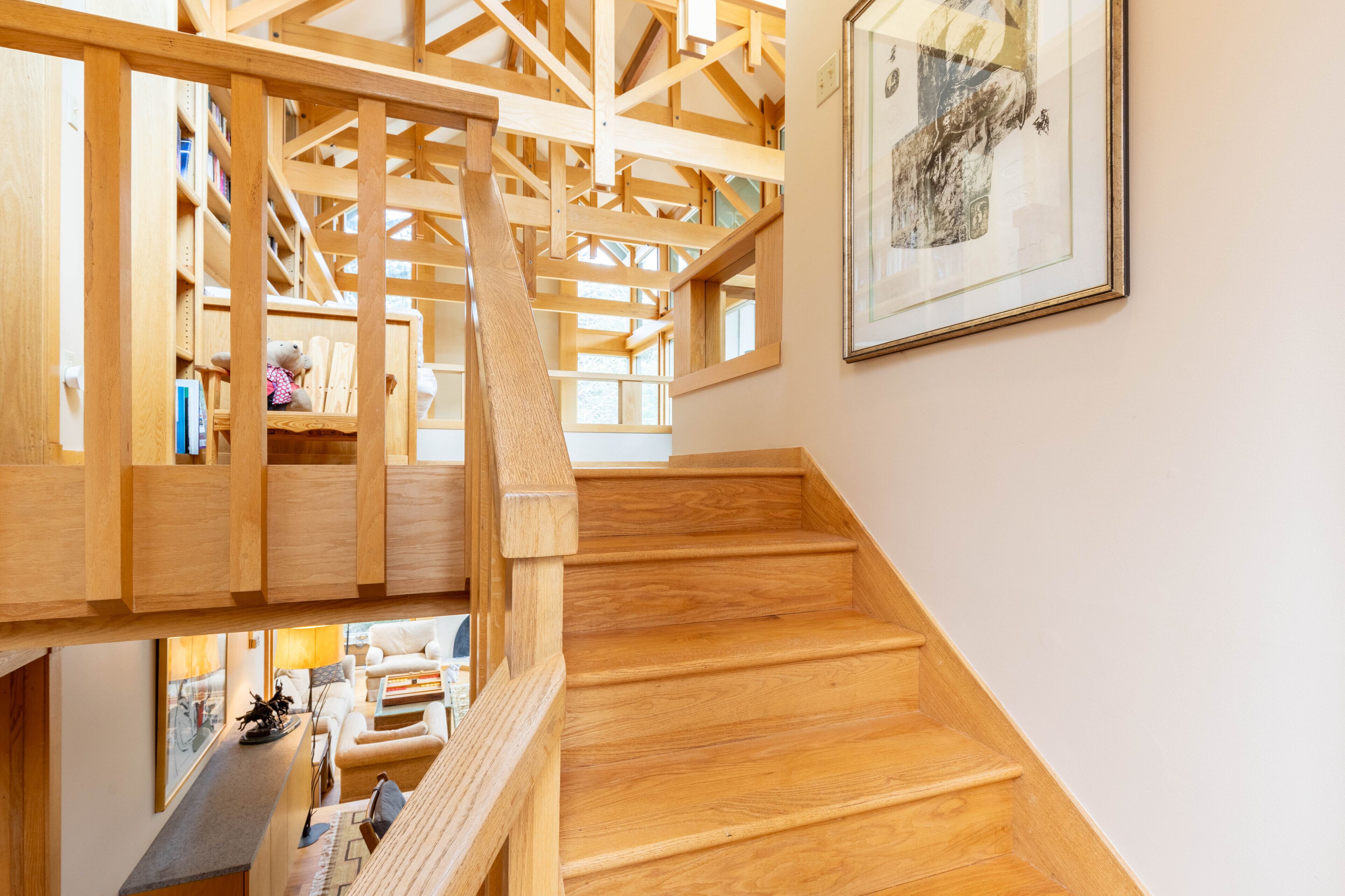 A wooden staircase with a view of a living area below.
