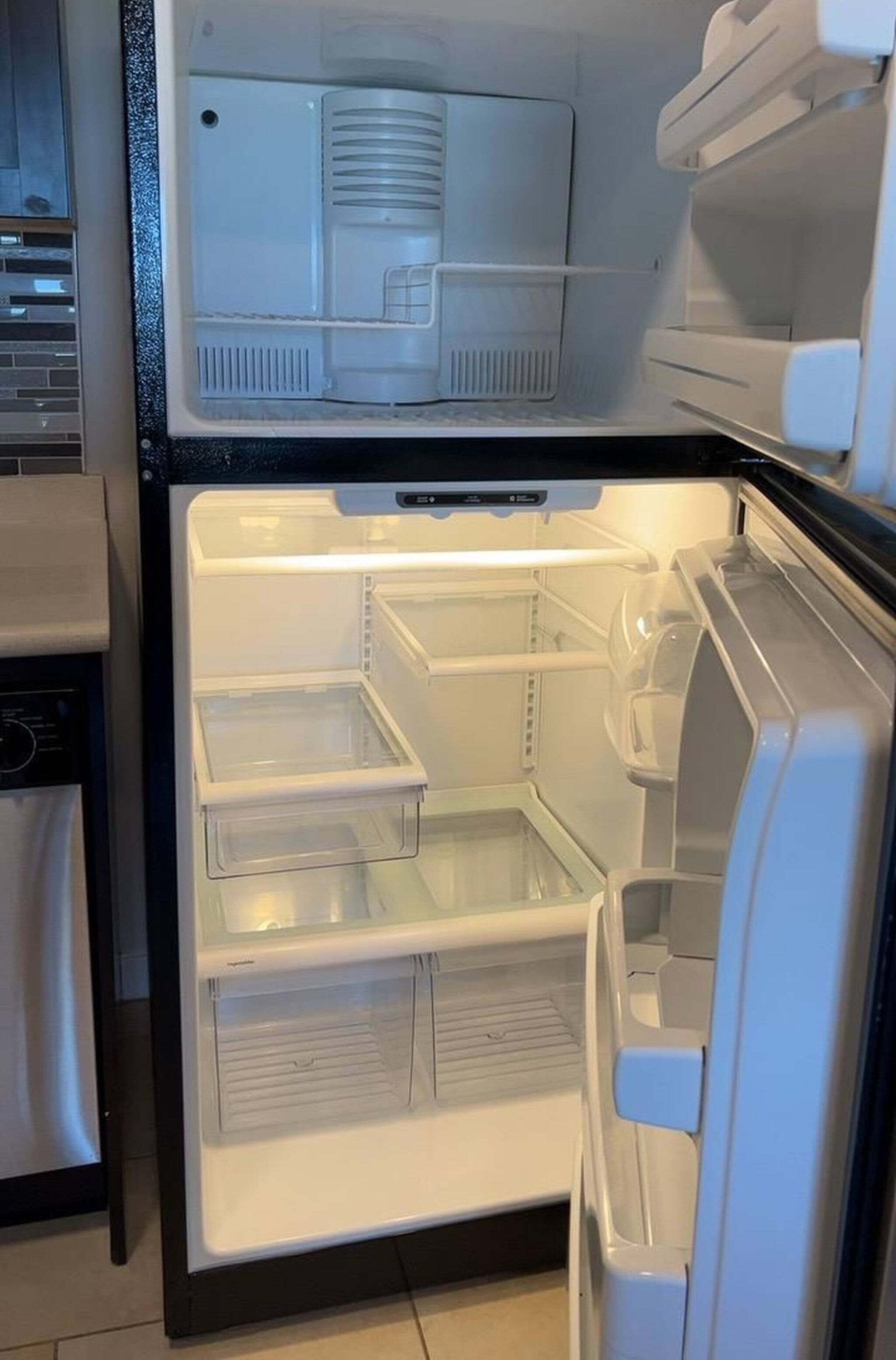 An open refrigerator with multiple shelves and a freezer compartment.
