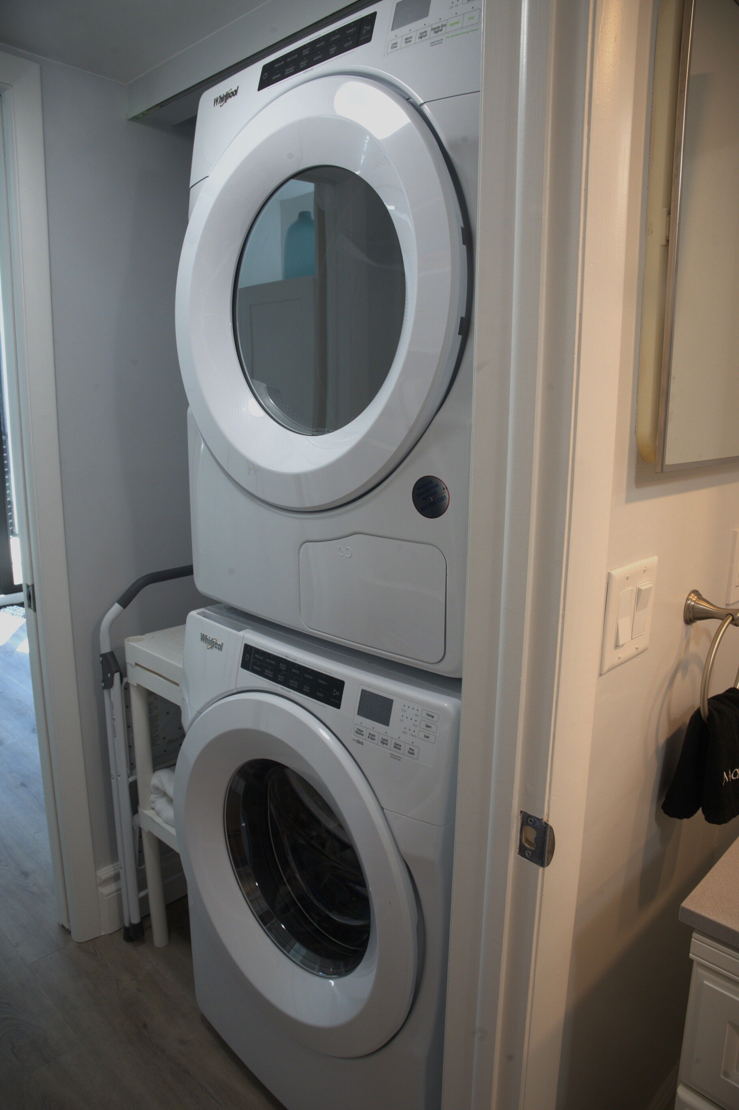 A stacked washer and dryer unit in a laundry room.